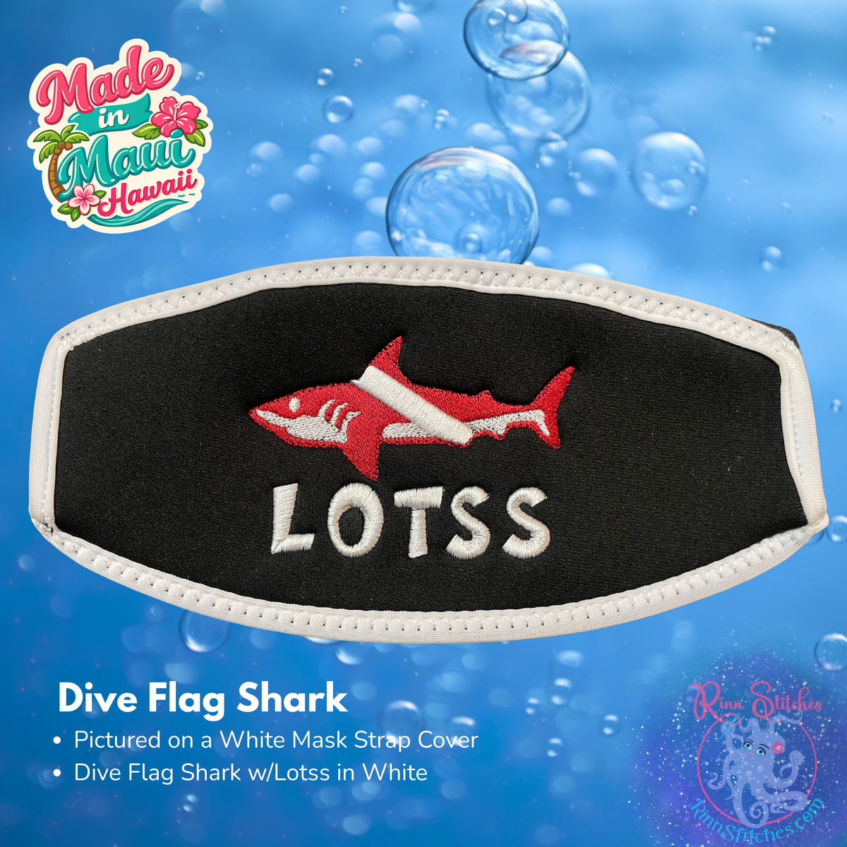 A black neoprene mask strap cover with white piping and an embroidered Dive Flag Shark with Lotss in white. 