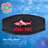 A black neoprene mask strap cover with black piping and an embroidered Dive Flag Shark with Scuba Dave in red. 