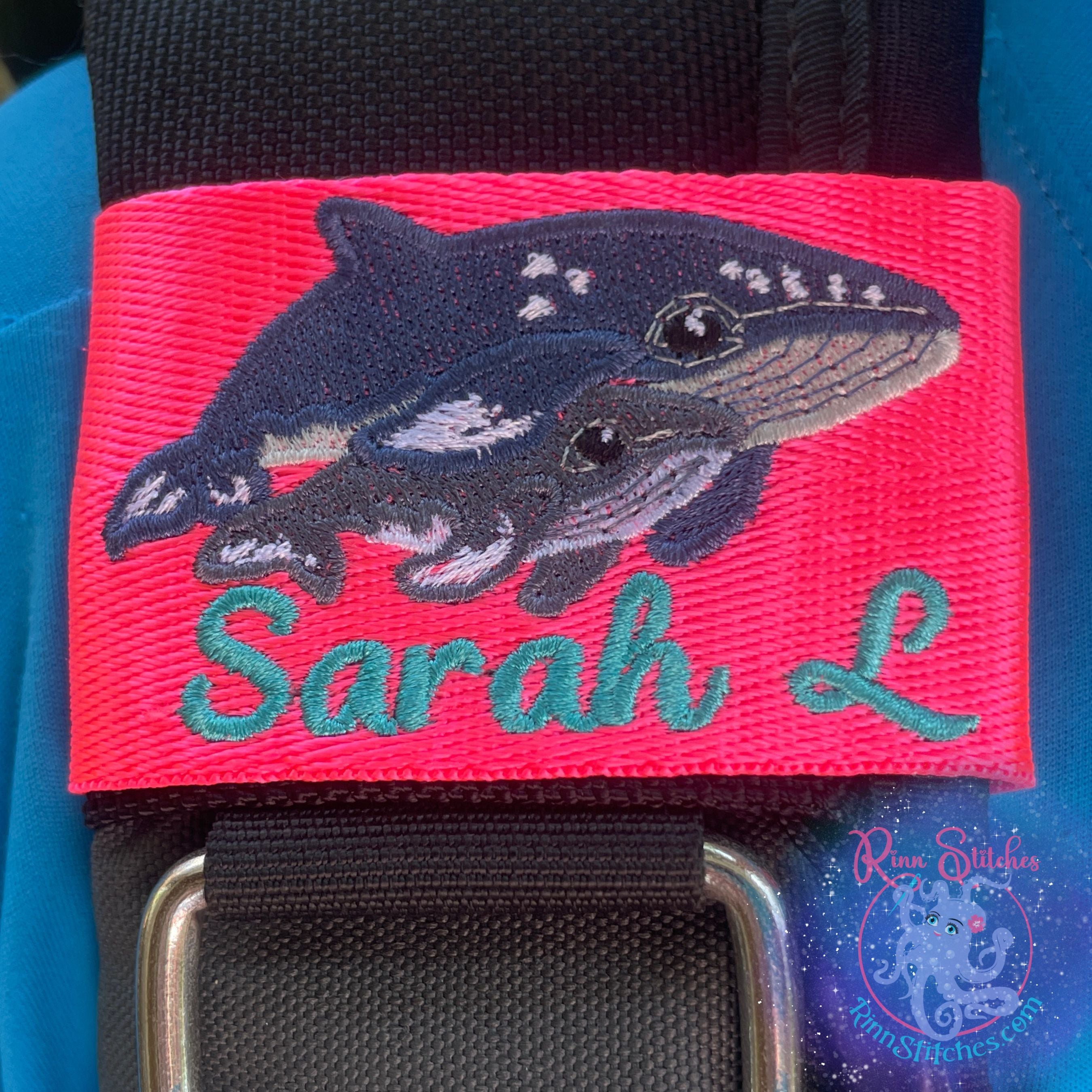 Humpback mama and calf embroidered design on a neon pink BCD Tag featuring the name Sarah L in Teal Thread in a Script font called Beach Days. Made by Rinn Stitches on Maui, Hawaii