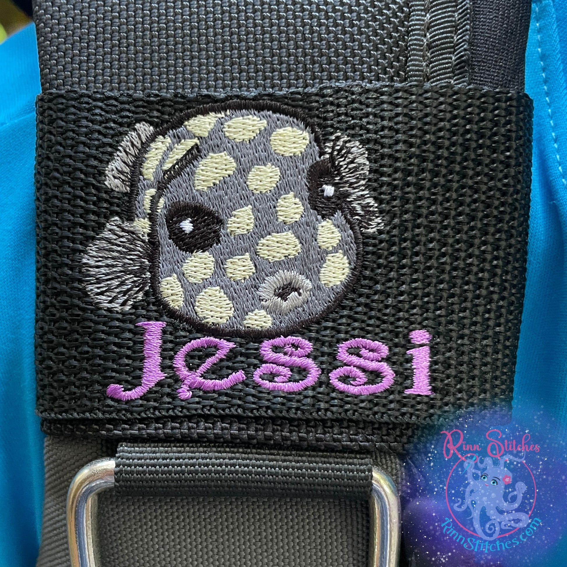 Embroidered juvenile trunkfish design in dark gray with light yellow spots. Featuring the personalization Jessi in purple thread below the cute little fishy. Made by Rinn Stitches in Maui, Hawaii