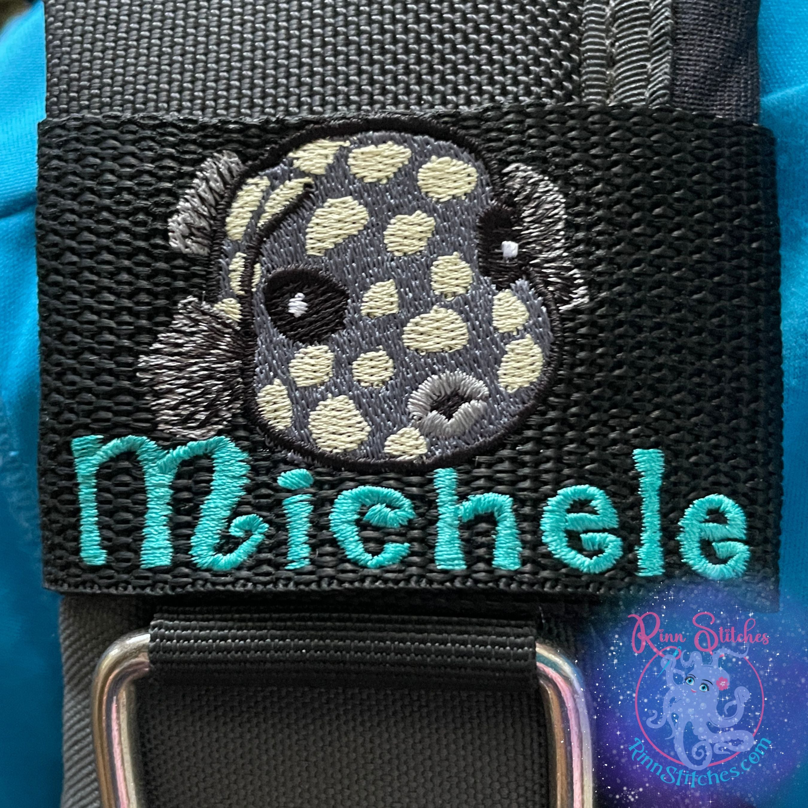 Embroidered juvenile trunkfish design in dark gray with light yellow spots. Featuring the personalization Michele in teal thread below the cute little fishy. Made by Rinn Stitches in Maui, Hawaii