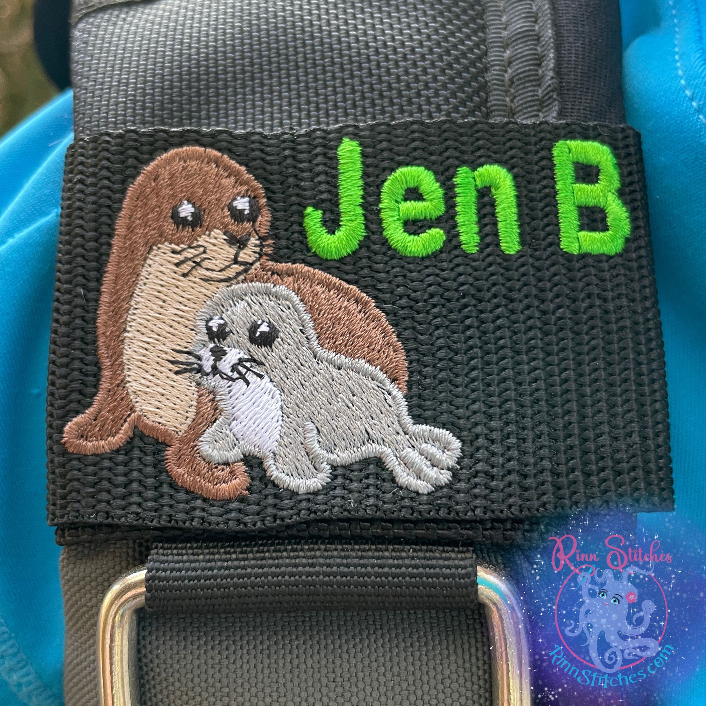 Monk Seal Mama and Baby embroidered design on black webbing BCD Tag for Scuba Divers, featuring the name Jen B in Neon Green Thread. Made by Rinn Stitches on Maui, Hawaii