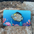 Ornate Butterfly Fish enamel pin on a colorful ocean theme backer card. Made by Golden Toad Studio, sold by Rinn Stitches.