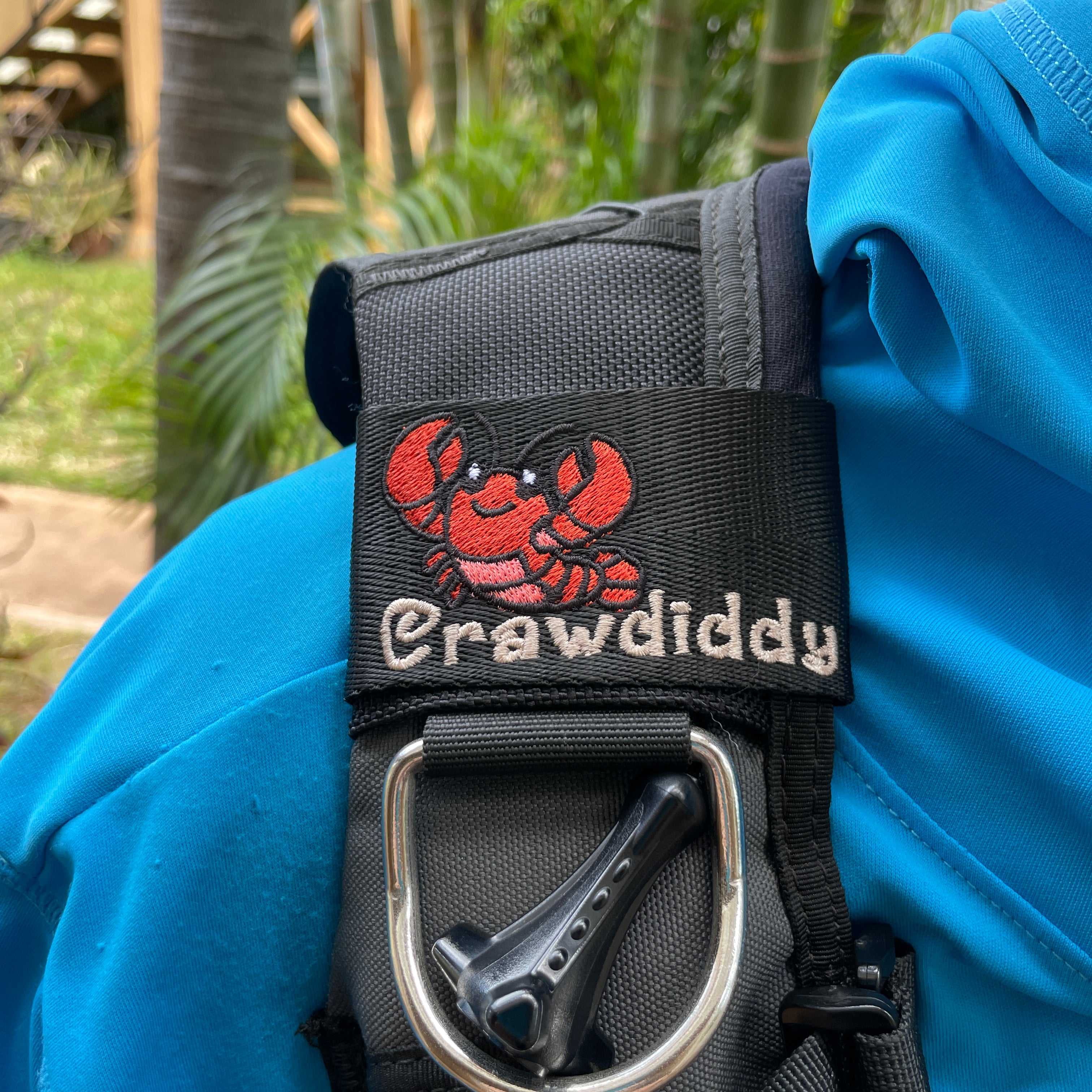 Embroidered BCD Tag featuring a red and coral crawdad design in a cute cartoon style with the name Crawdiddy on the bottom in beach sand color thread. Made by Rinn Stitches in Maui, Hawaii